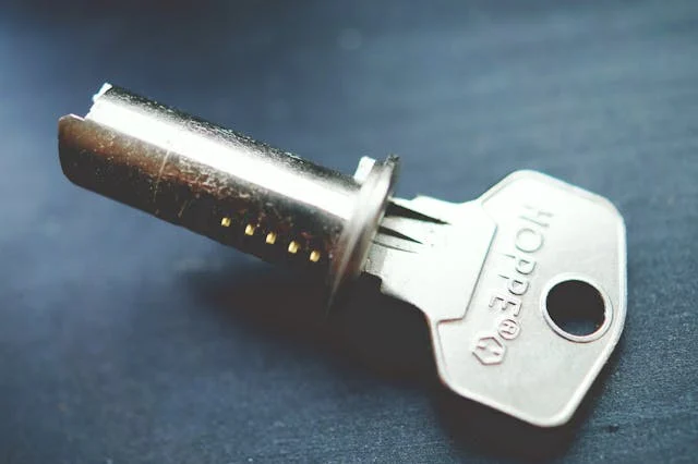 Close-up of a key and lock cylinder on a dark surface